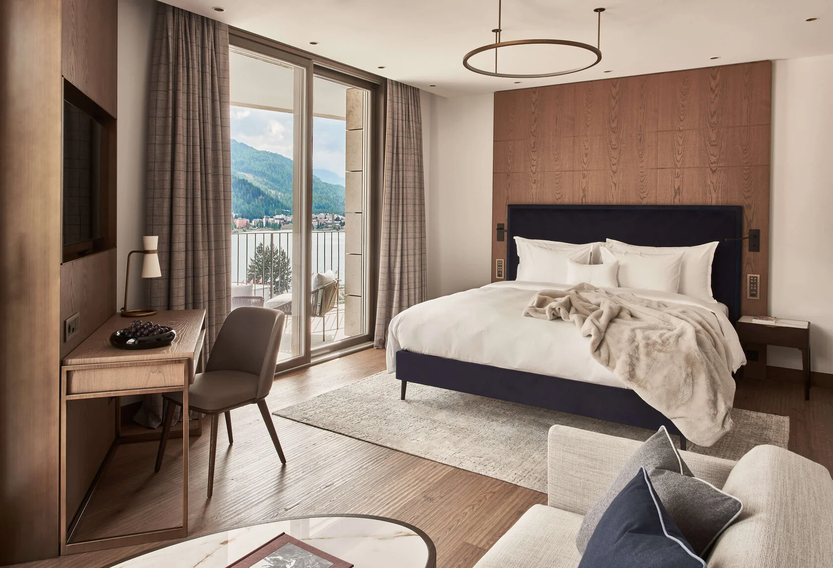 Junior Suite mit Holzwand, blauem Bettkopf und Balkon zum See