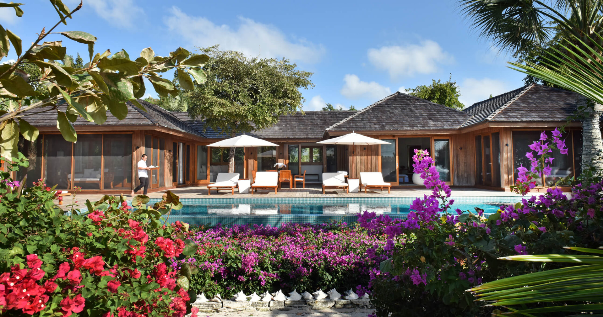 Rocky Point Villa hinter blühender Bougainvillea am langen Pool