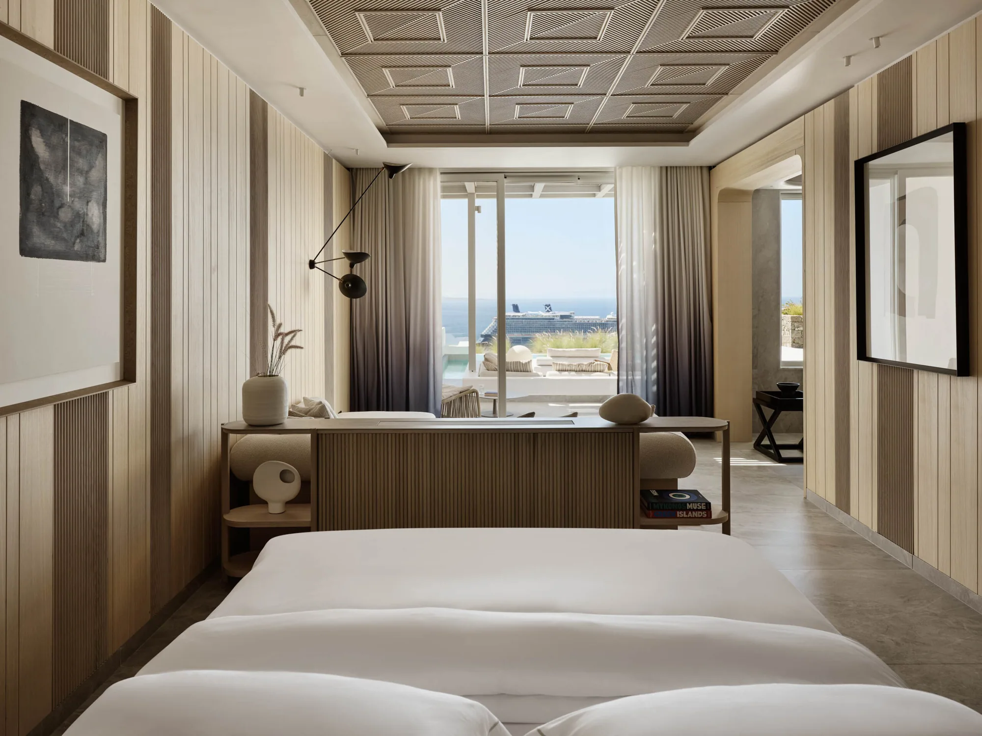 Schlafzimmer einer Suite mit Fensterfront zum Meer