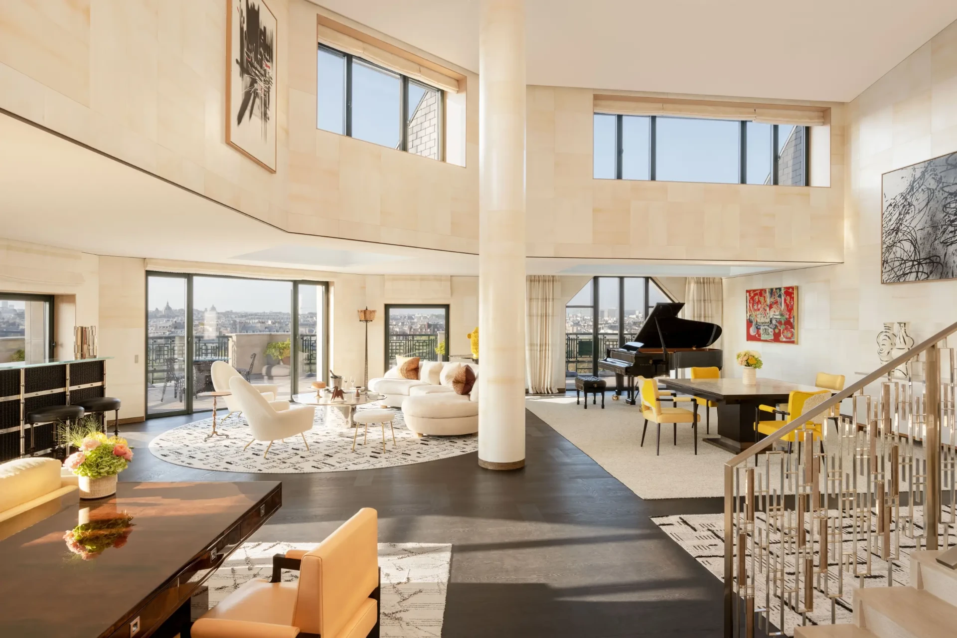 Wohnbereich der Ravel Suite mit Flügel, heller Steinverkleidung und geöffneter Fensterfront über Paris