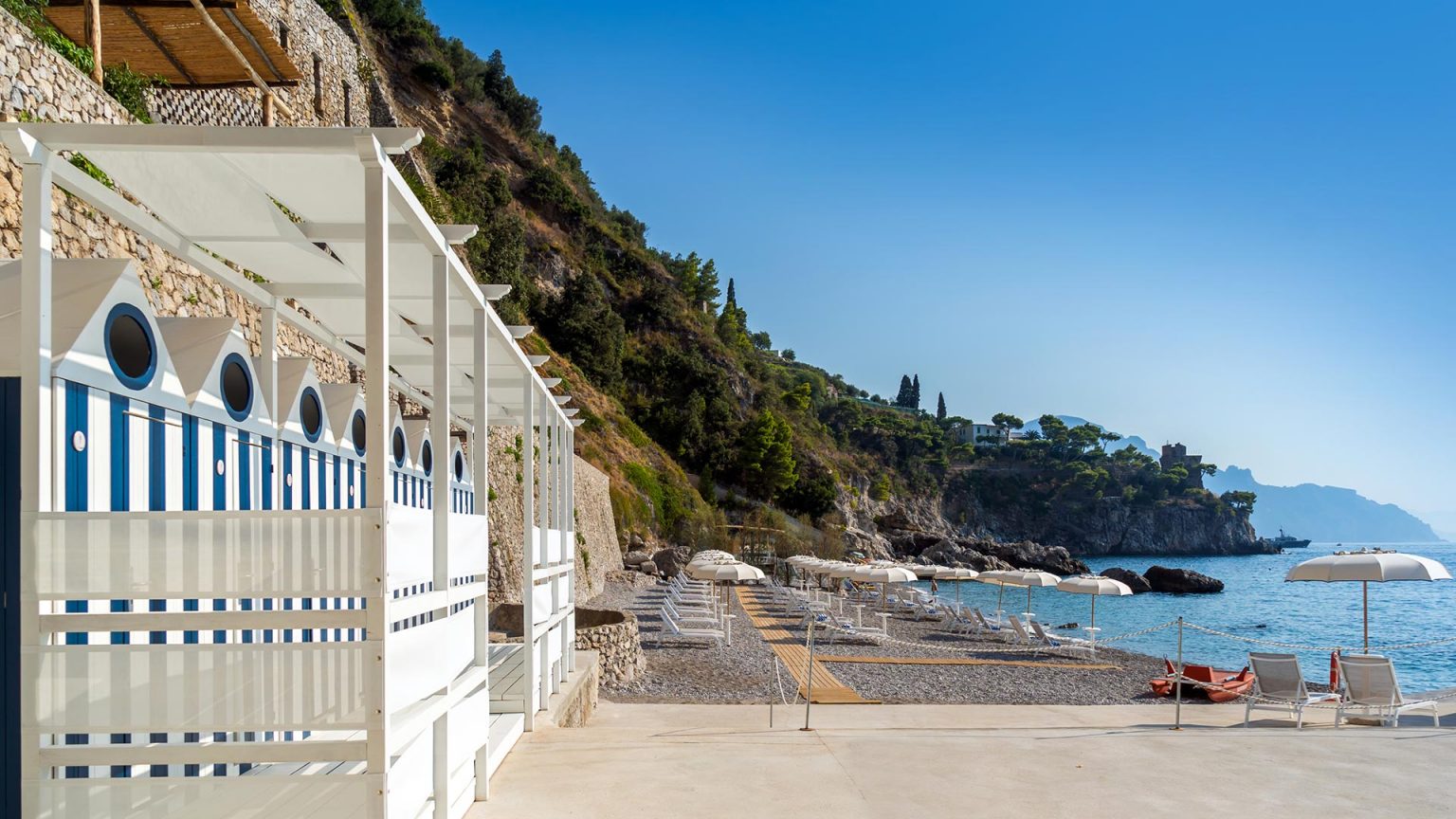 Weiss-blau gestreifte Cabanas am Strand des Borgo Santandrea