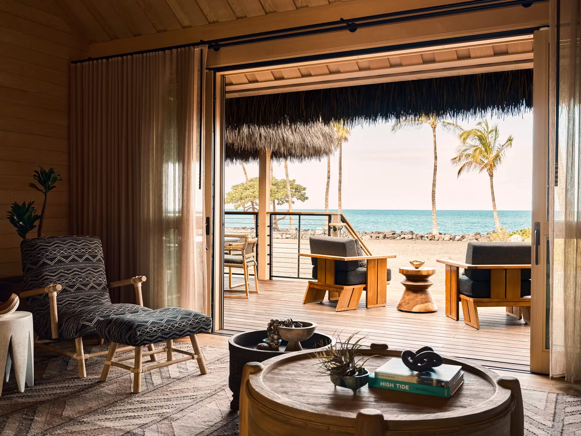 Wohnbereich eines Oceanfront Hale im Rosewood Kona Village mit Blick über schwarzes Lavagestein zum Meer