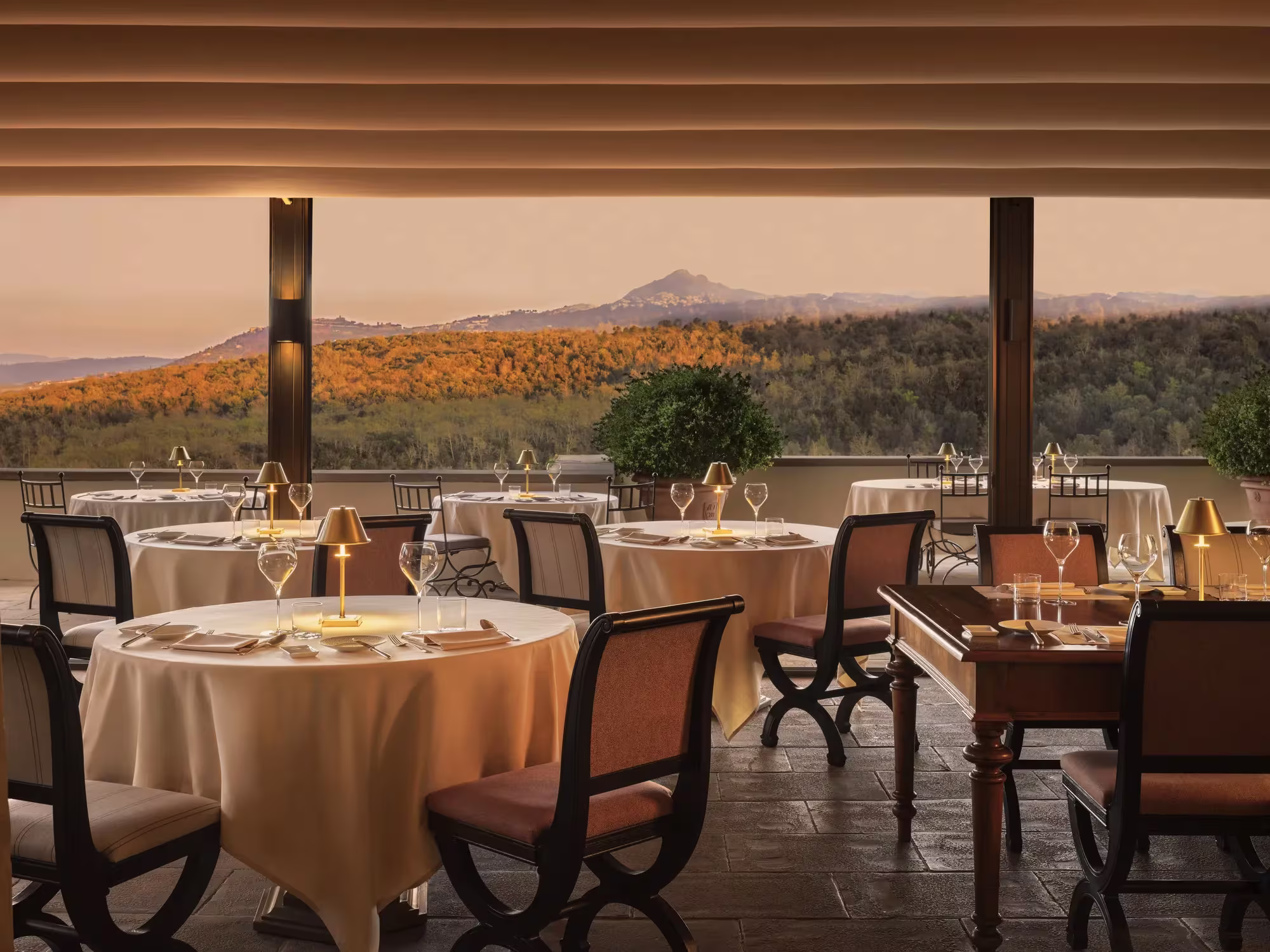 Abendlich gedeckte Tische des Ristorante Campo del Drago in Castiglion del Bosco im warmen Licht