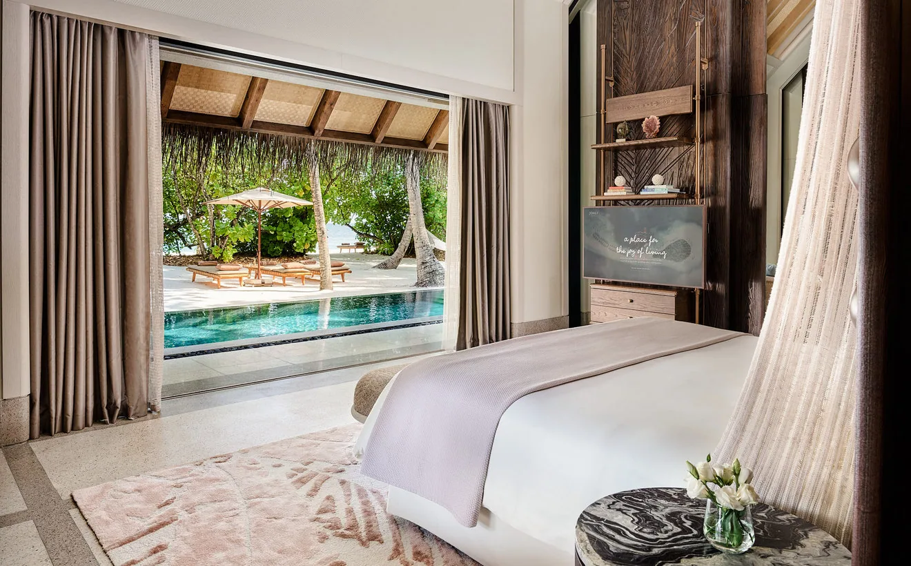 Schlafzimmer einer Villa von JOALI mit Blick auf Pool und Lagune