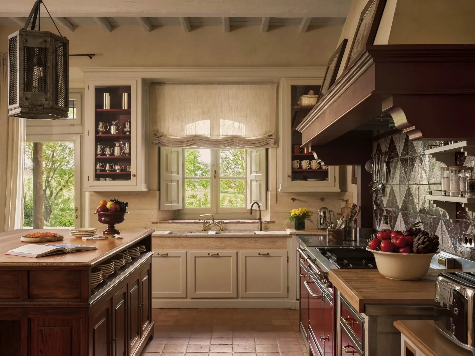 Küche der Villa Biondi mit offenem Kamin, Kupfergeschirr und Fenster zum Garten
