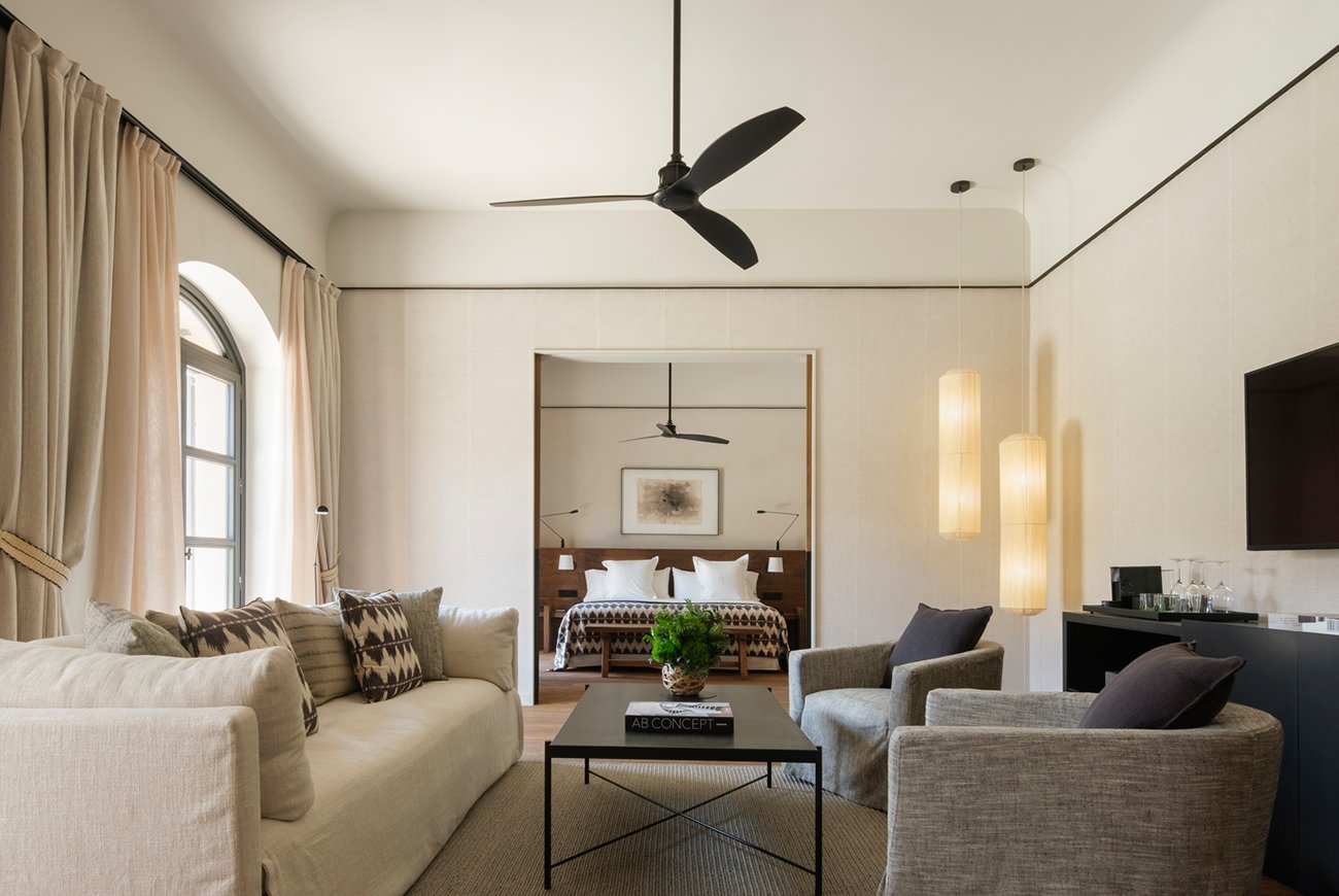 Wohnbereich einer Suite mit Leinensofas und Blick in den Schlafraum