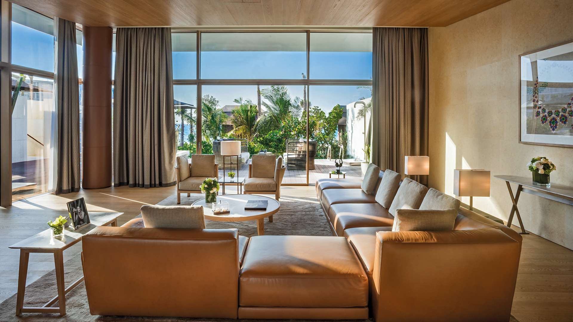 Wohnraum einer Villa mit bodentiefen Fenstern zum Meer