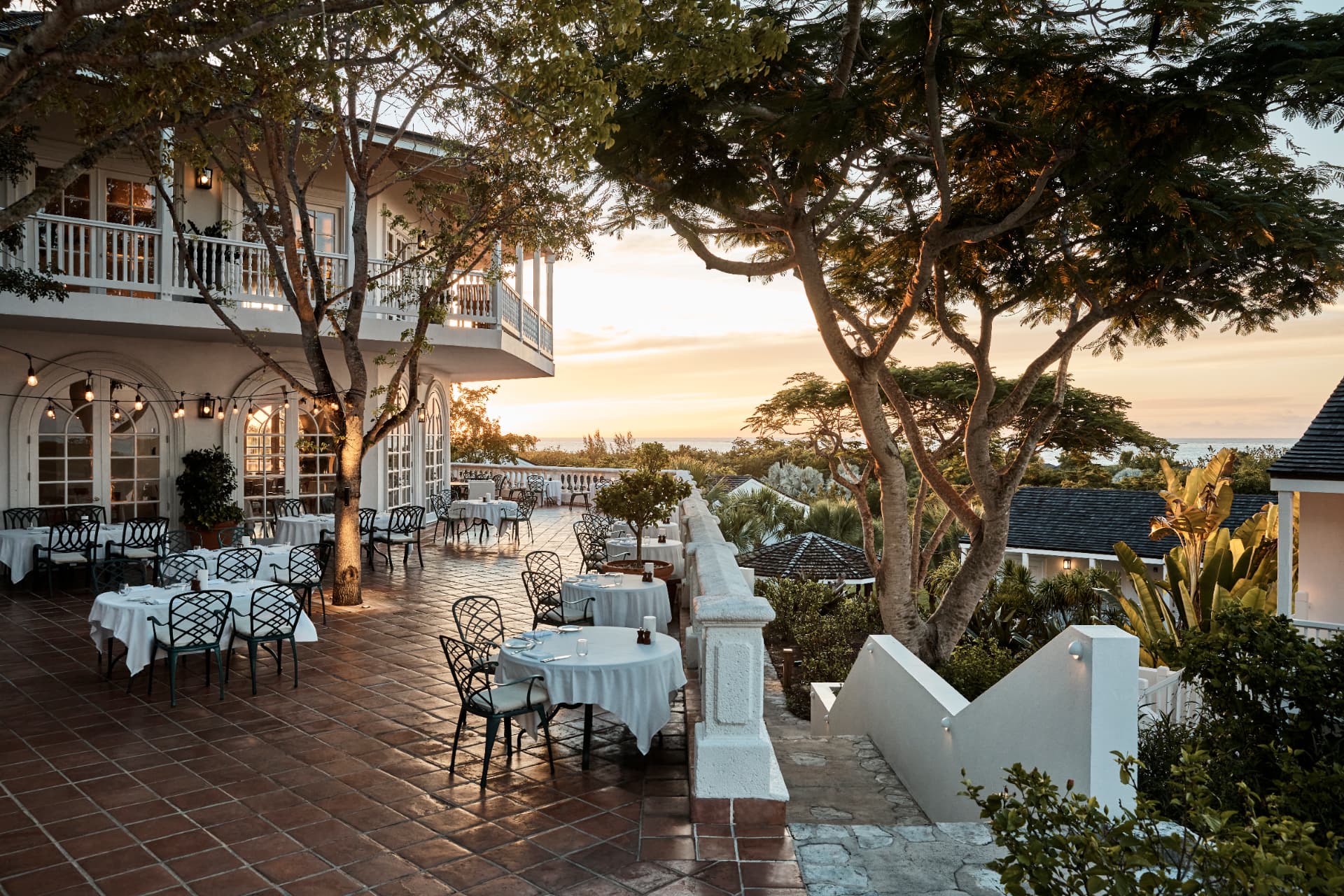 Terrace Restaurant am Abend: weiß gedeckte Tische unter Bäumen im letzten Licht