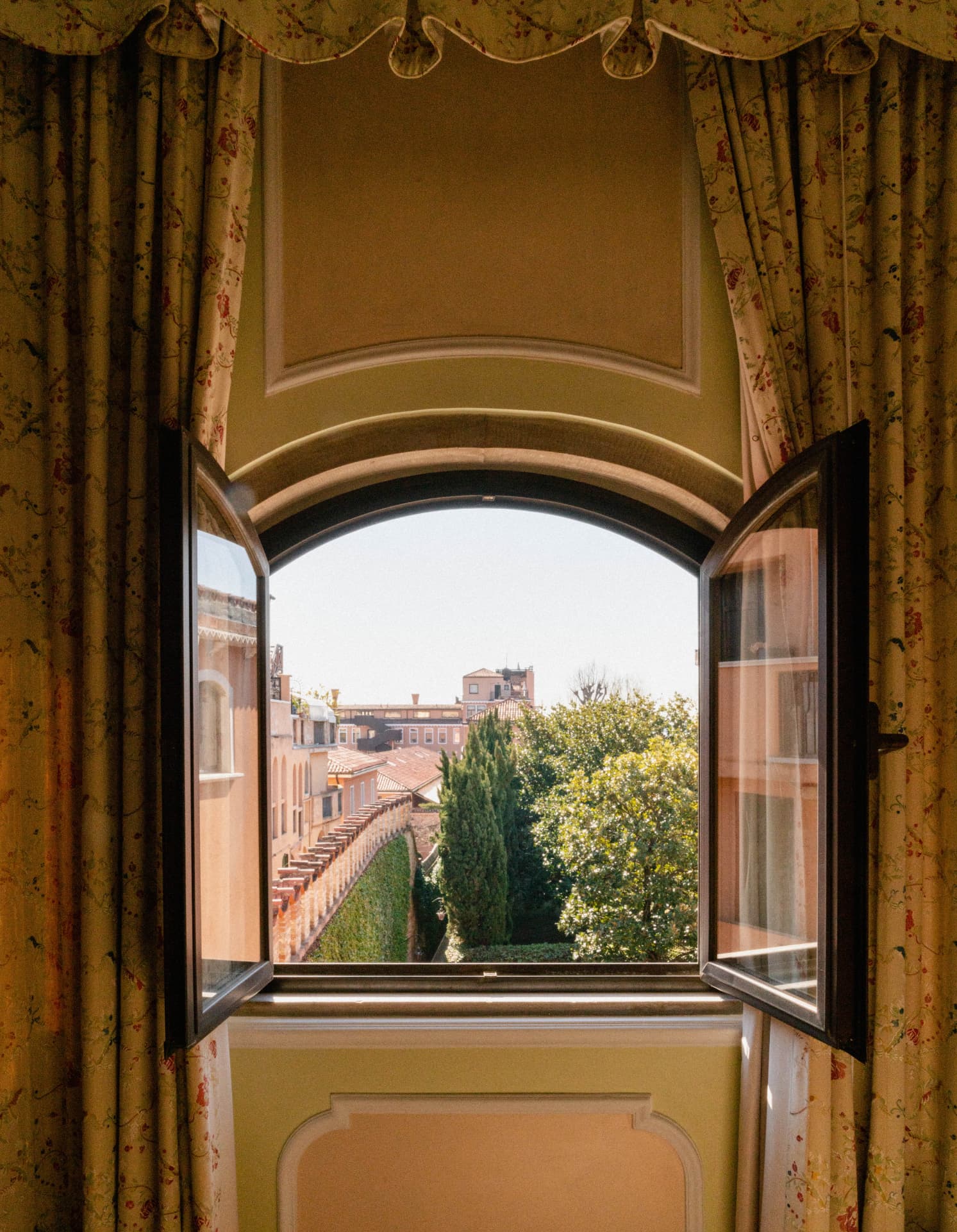 Geöffnetes Bogenfenster einer Suite mit Blick über Gärten und Dächer der Giudecca