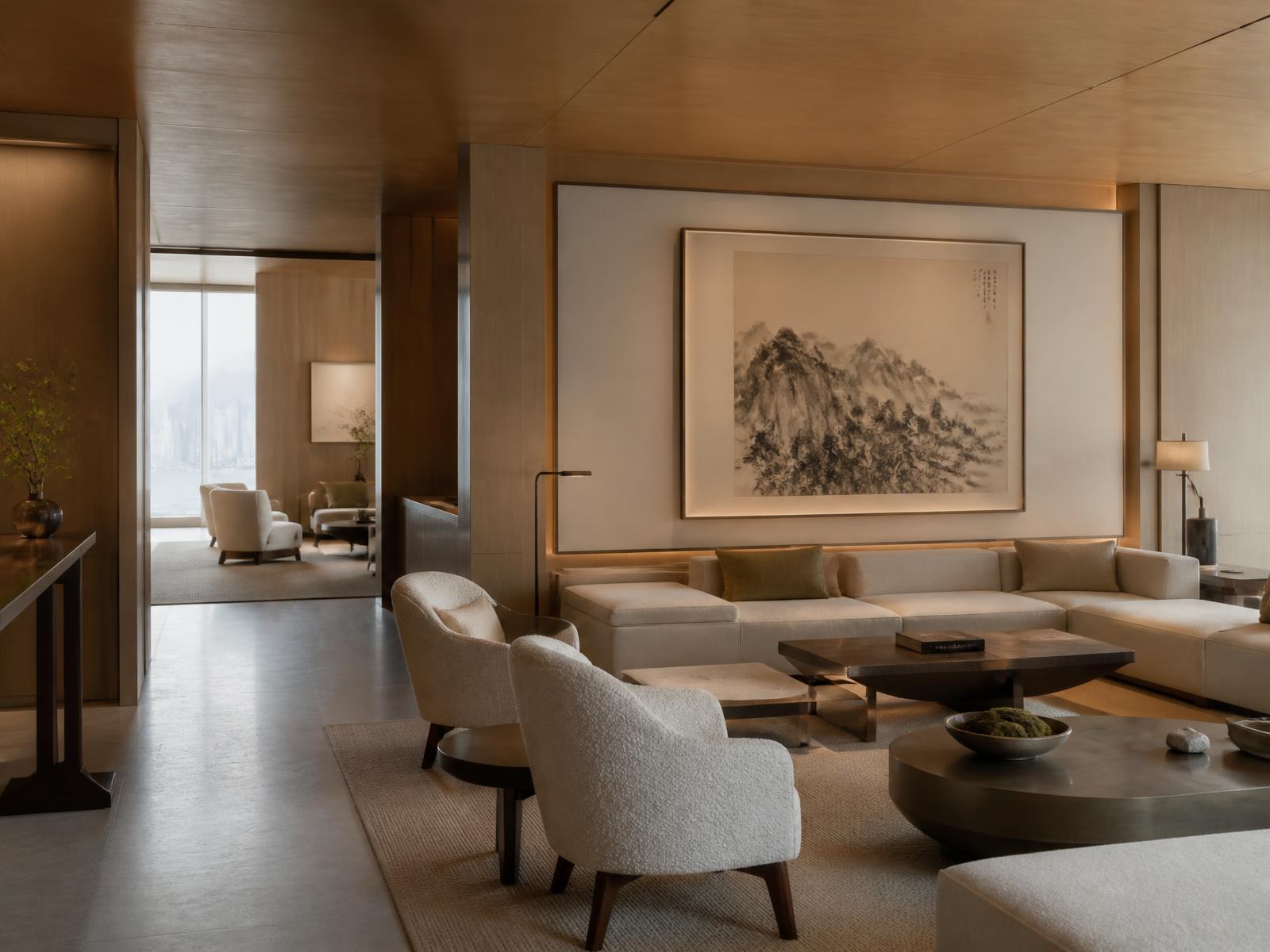 Hotel lounge in Hong Kong with natural stone floors, warm oak panelling, bronze detail, custom linen furniture and a contemporary Chinese ink painting lit softly