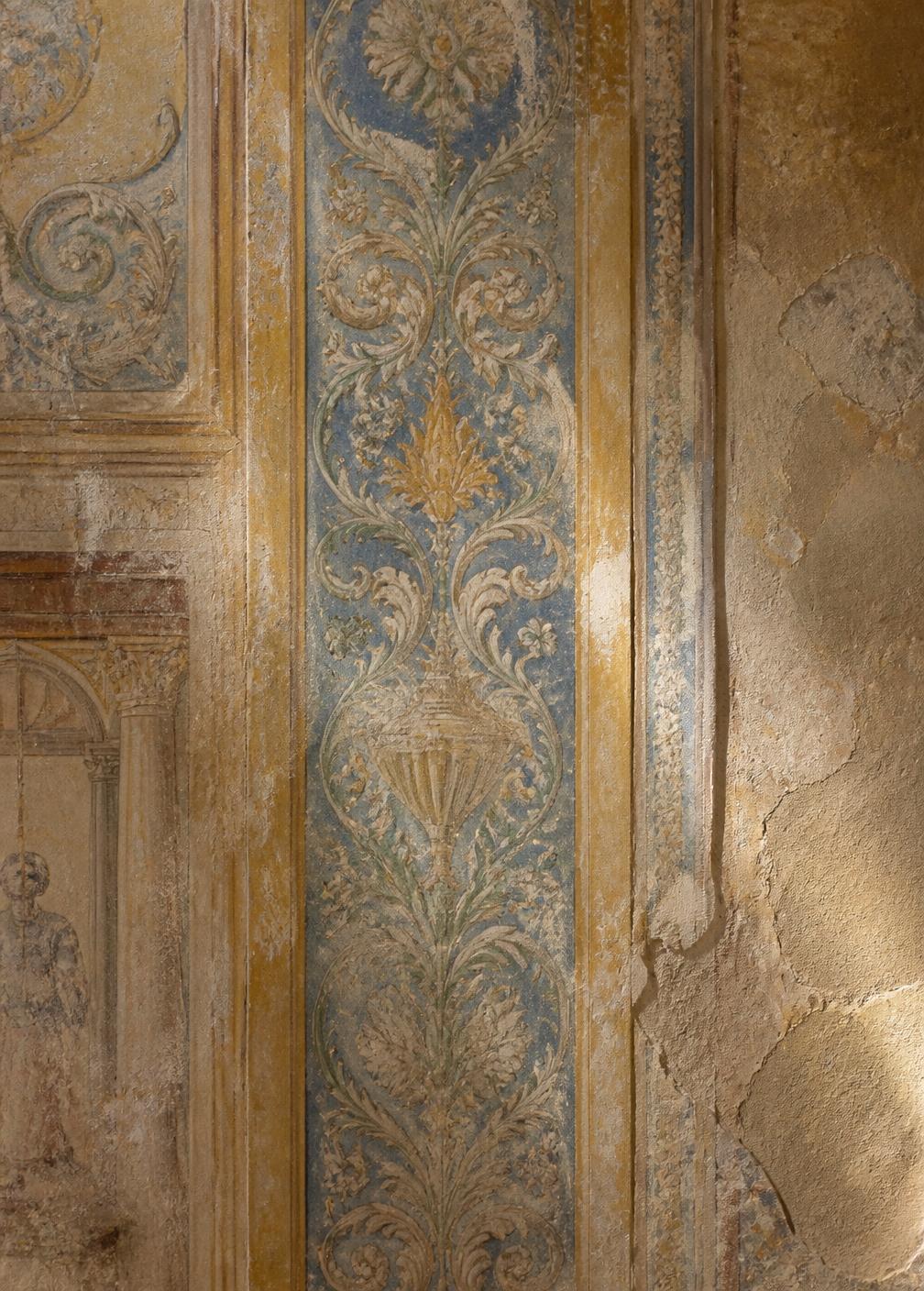 Detail of an original Renaissance fresco on a palazzo wall, faded blue and ochre pigment on cracked plaster in raking daylight