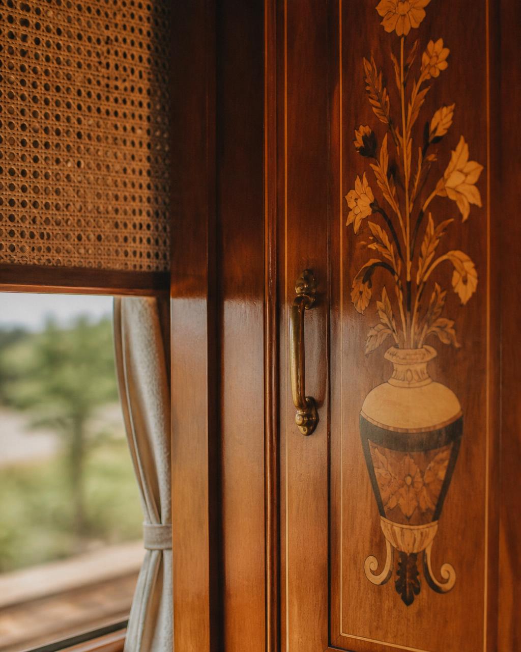 Detail of polished timber marquetry, rattan cane weave and a brass handle inside a colonial luxury train carriage