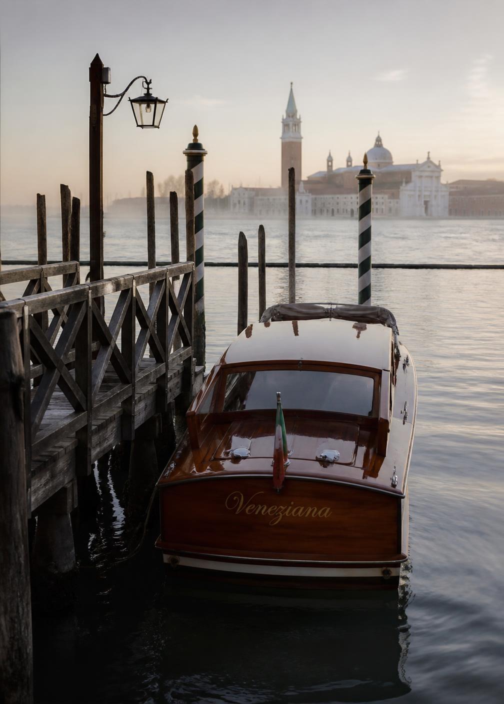 Varnished mahogany water taxi moored at a wooden Venetian pier at first light with striped mooring poles