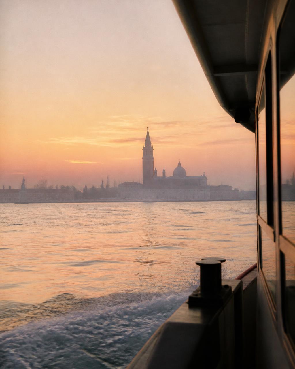 The Venetian lagoon at first light with the campanile and domes of San Giorgio Maggiore in soft pink mist