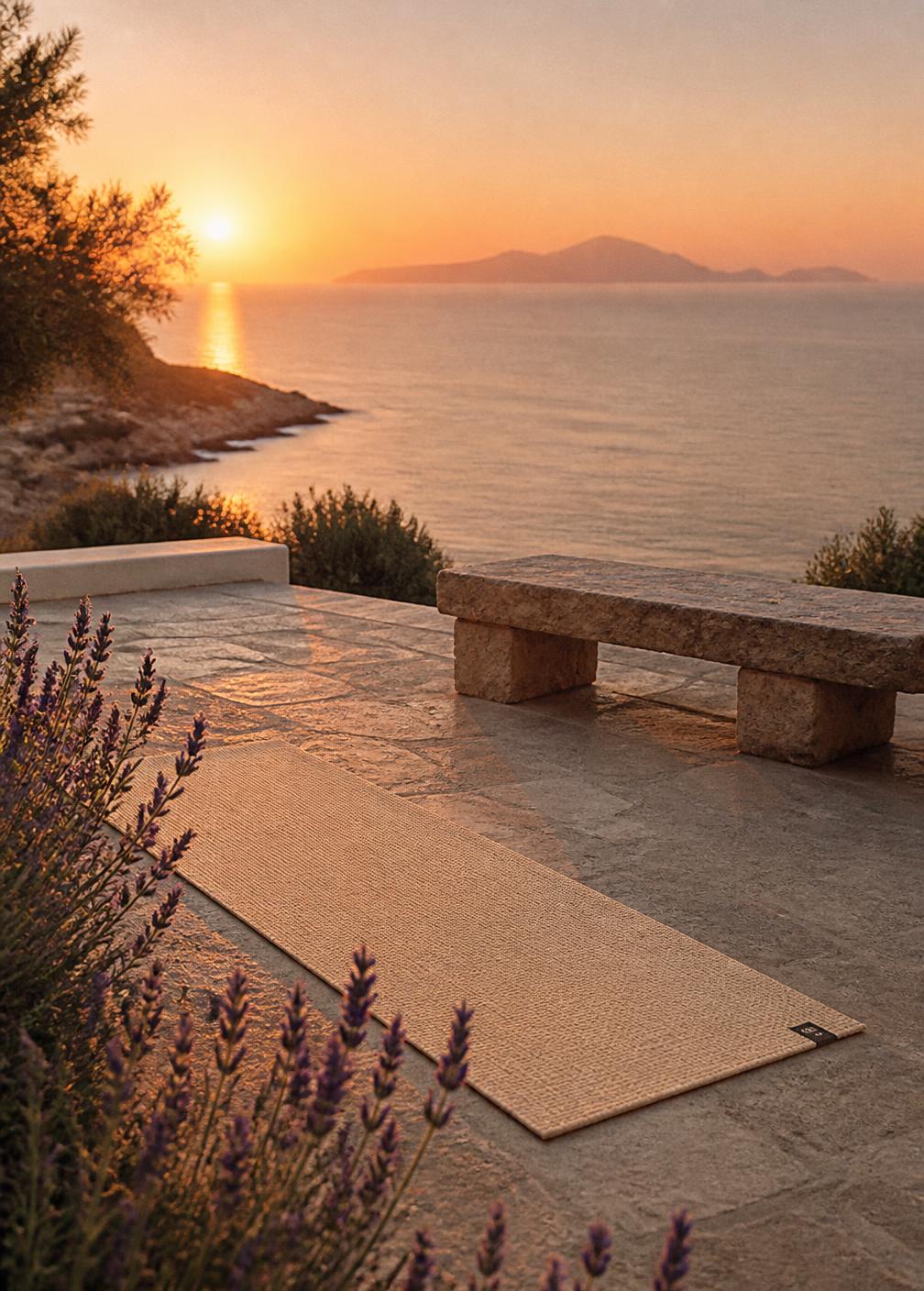 Empty linen yoga mat and stone bench on a terrace facing the Mediterranean at sunset with lavender in the foreground