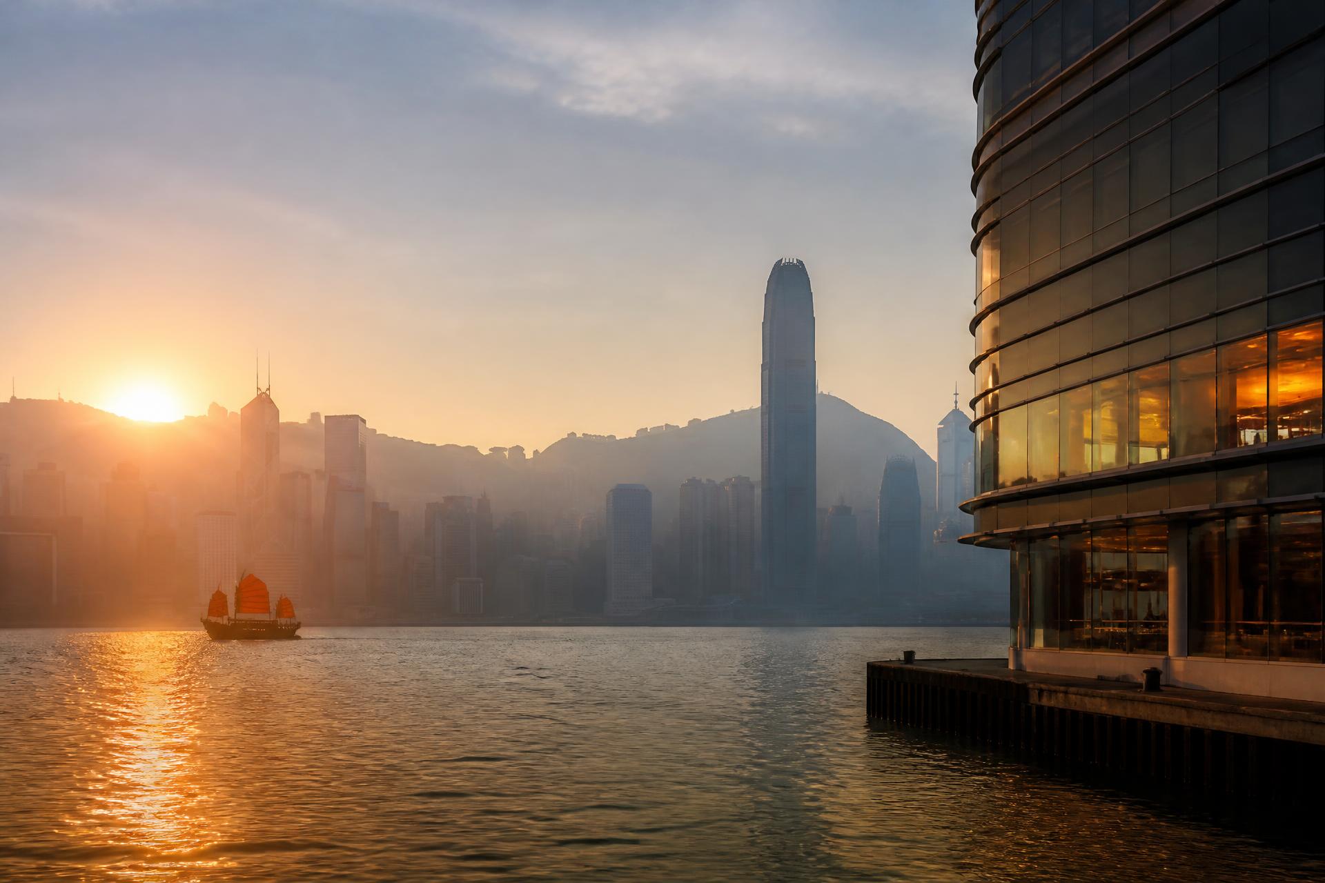 Sunrise over Victoria Harbour in Hong Kong with morning mist and the island skyline in silhouette