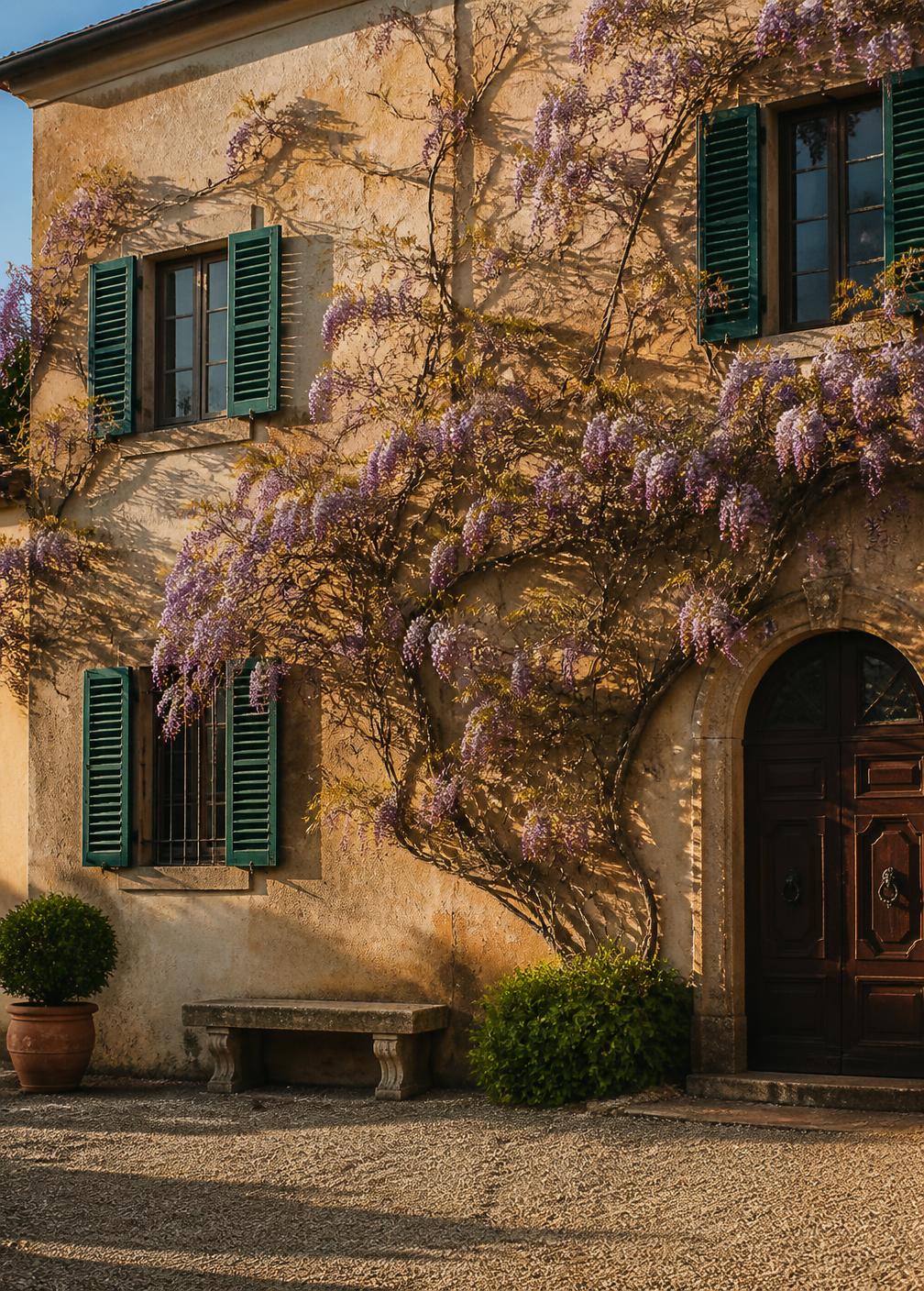 Honey-coloured Tuscan villa facade with green shutters and wisteria in warm evening light