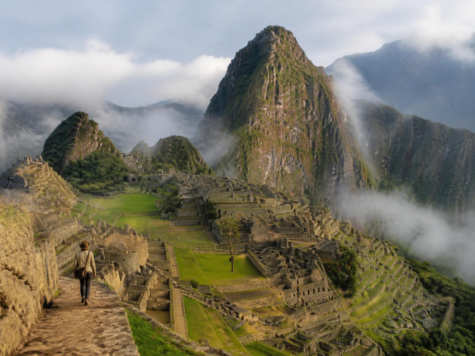 Machu Picchu im frühen Morgennebel, steinerne Terrassen und grüne Gipfel im weichen Goldlicht