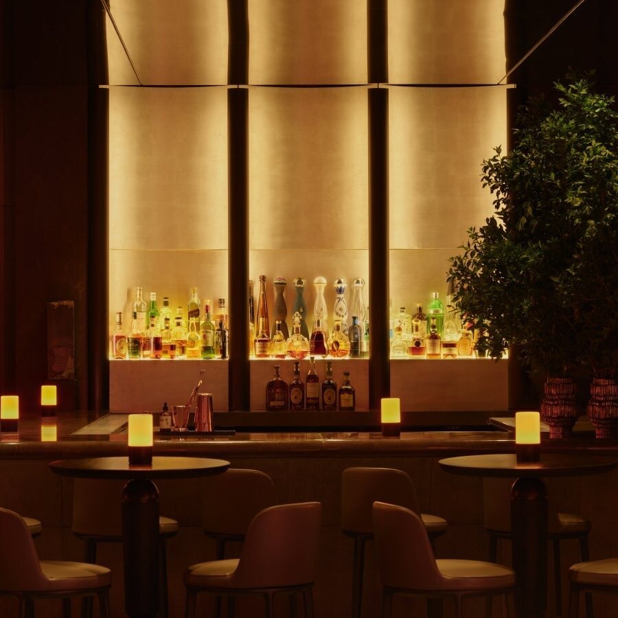 Die beleuchtete Rückwand der Bar im Jazz Club mit Flaschen in Nischen und Kerzenlicht auf dem Tresen