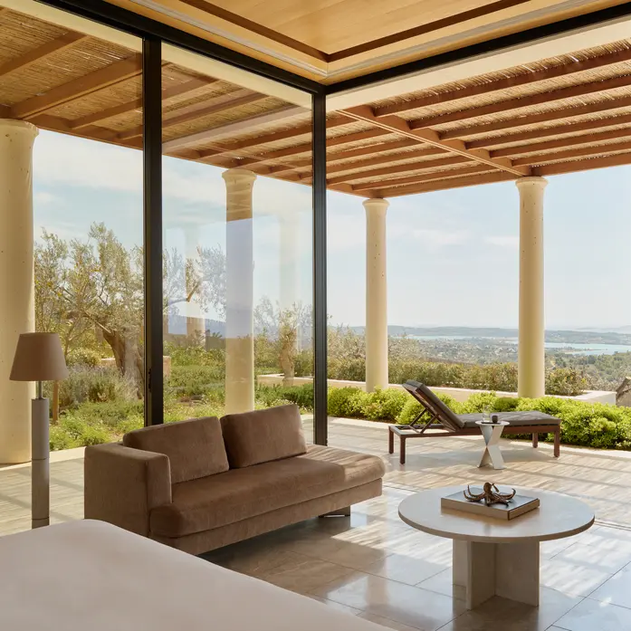 Amanzoe-Pavillon mit Glasfront zur eigenen Terrasse, Liege unter der Schilfpergola und Blick über Olivenbäume auf die Bucht von Porto Heli
