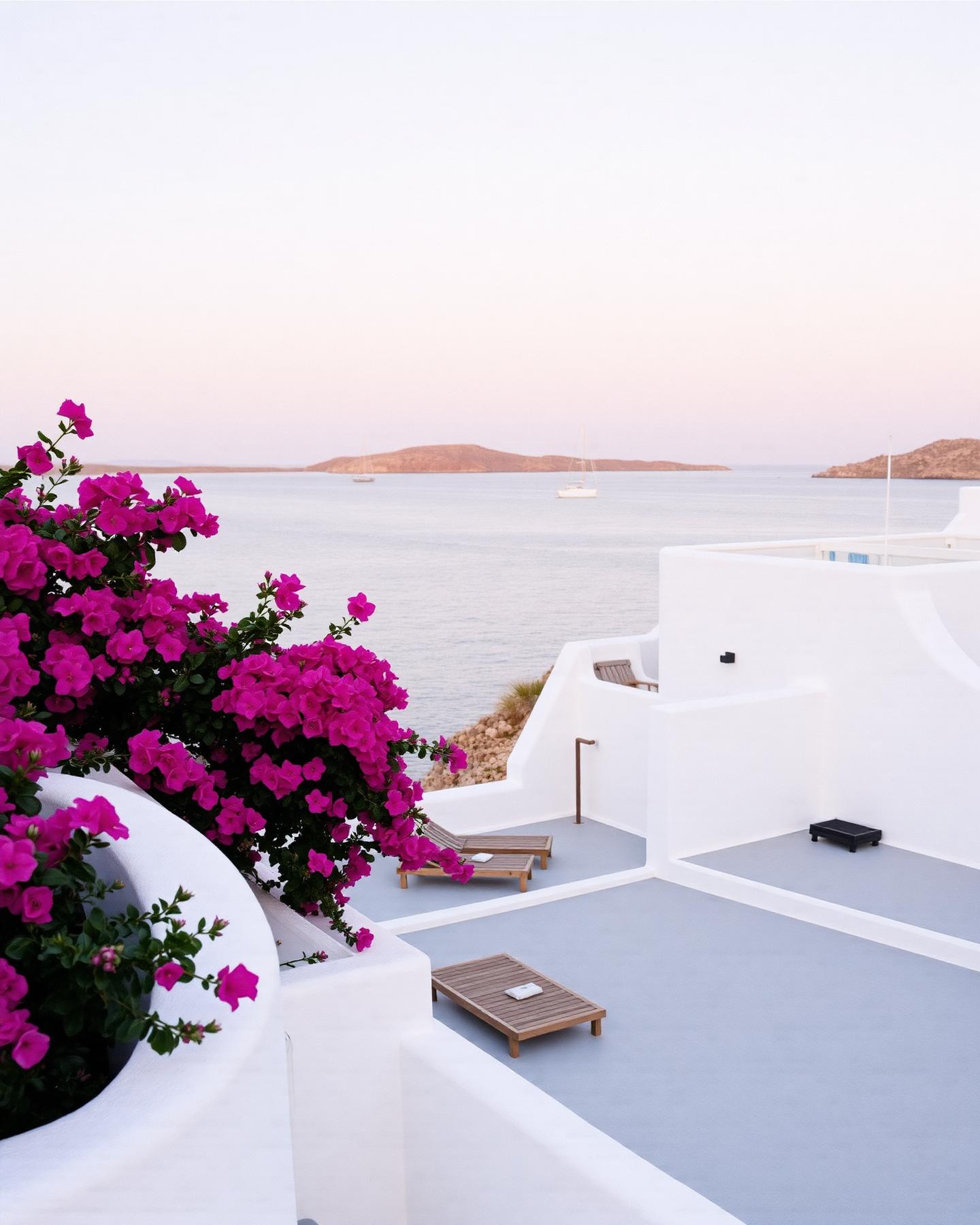 Weisses Resort über einer privaten Bucht auf Mykonos mit Bougainvillea und Segelbooten