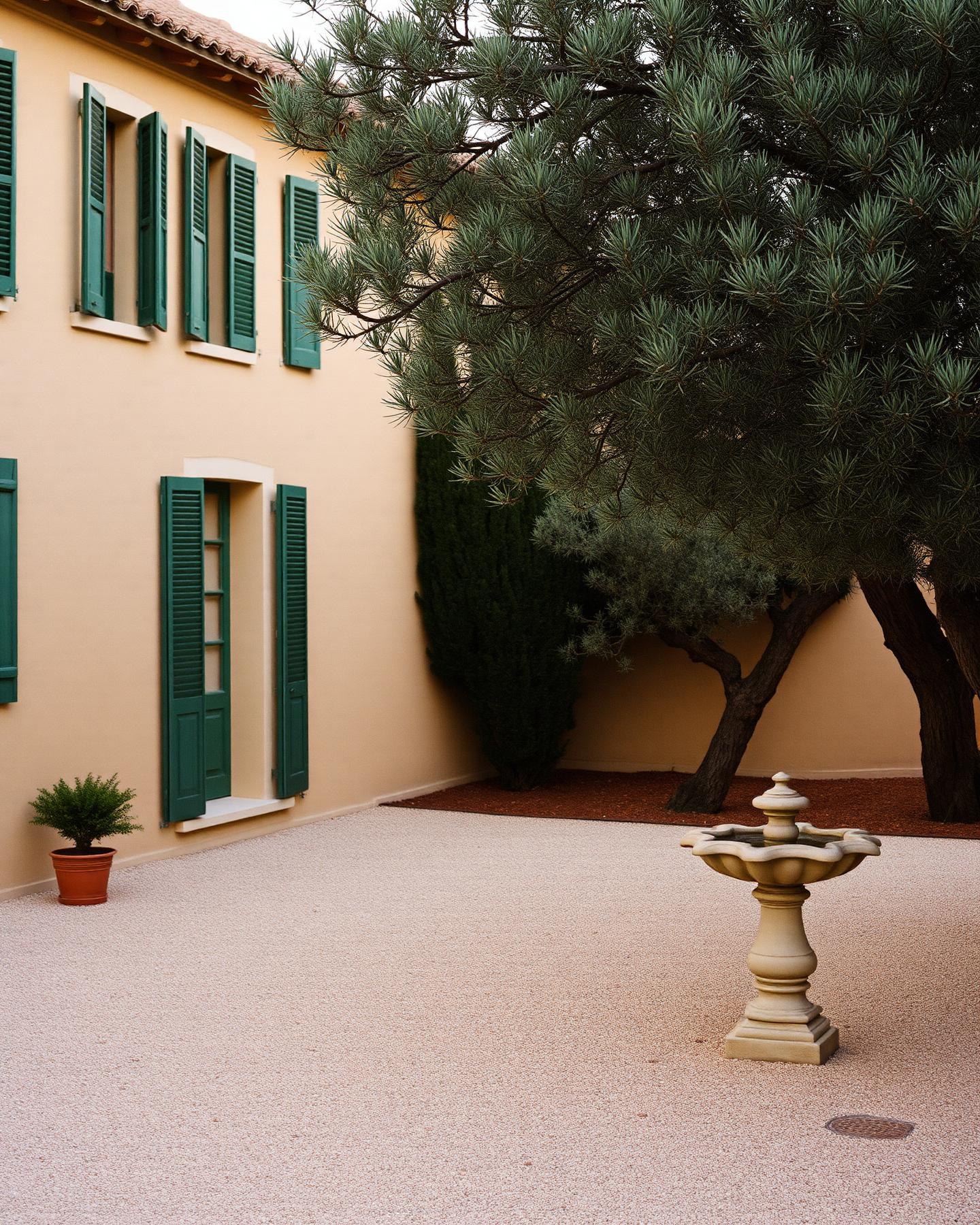 Mallorquinisches Landgut aus honigfarbenem Stein mit grünen Fensterläden und Olivenbäumen